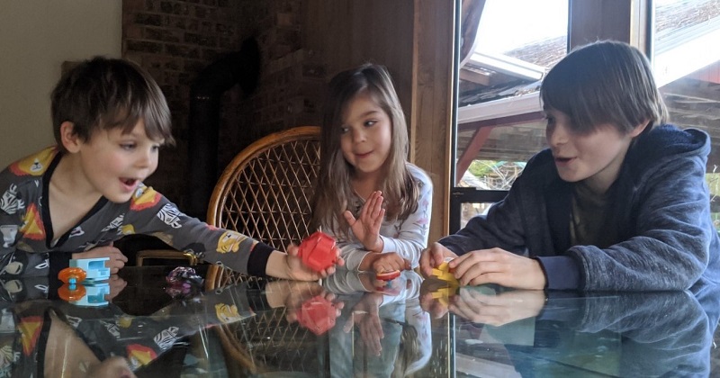 3 kids playing at kitchen table
