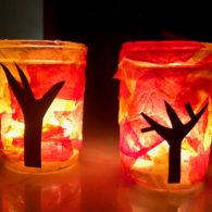 Mason jar fall tree luminaries glowing with orange and red tissue paper.