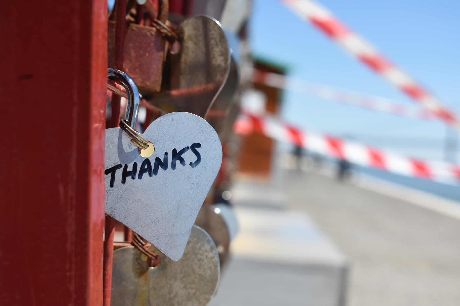 Heart-shaped keychain on a bridge engraved with the word “Thanks,” symbolizing gratitude and appreciation.
