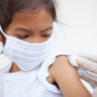 Flu shot: Masked girl getting an injection.