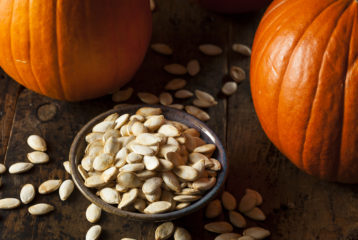 A tray of roasted pumpkin seeds fresh out of the oven, golden and seasoned.