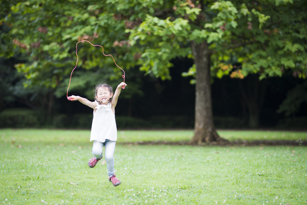 Picks. Girl jumping rope a park.