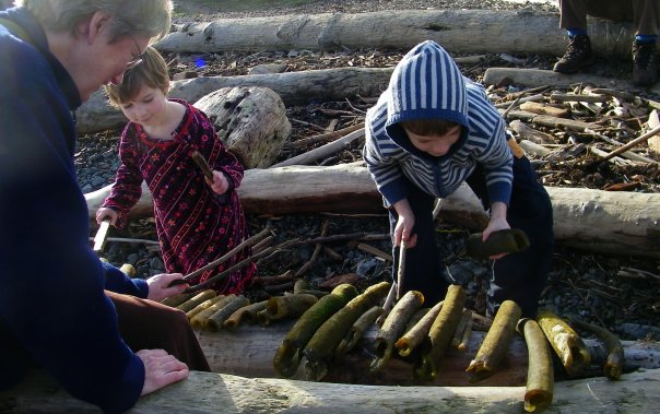 Play outside: grandmother watches two kids play with a xylophone made of kelp