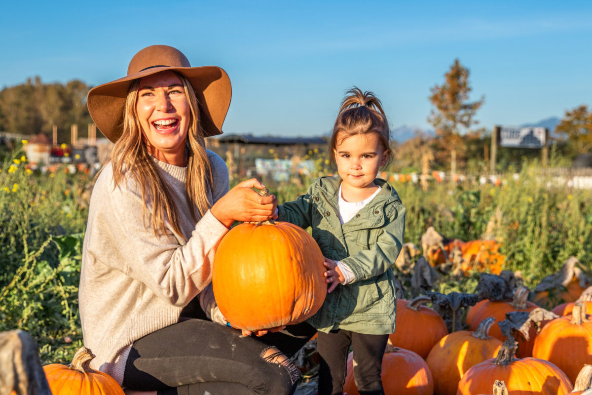 Farm country: woman and child with pumpkin in Stocker Farms pumpkin patch