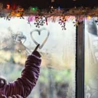 Erika's weekend picks: a girl in a winter coat and hat, drawing a heart in the fogged up window of a train car
