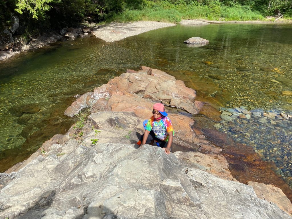 boy on rock in river