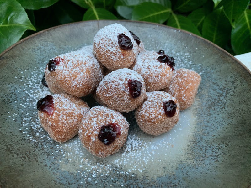 Plate of mini sufganiyot — powdered sugar–coated Hanukkah jelly doughnuts inspired by Sadie Davis-Suskind’s family recipe.