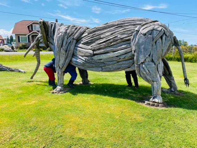 Children enter the underbelly of the elephant.