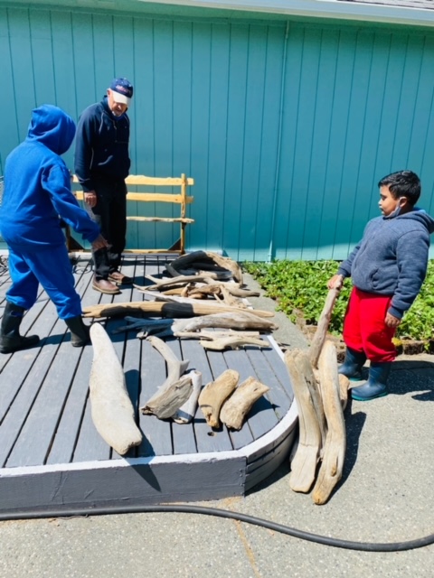 Children telling Joe Treat about what they see in the driftwood.