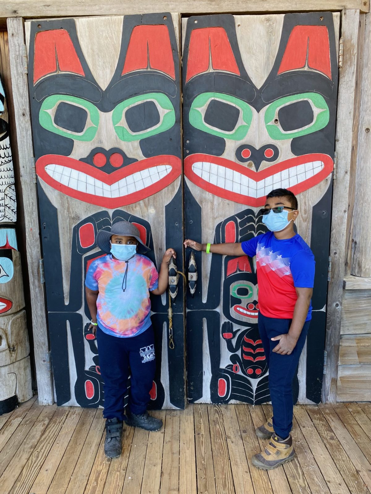 Children in front of large doors adorned with Native American Art