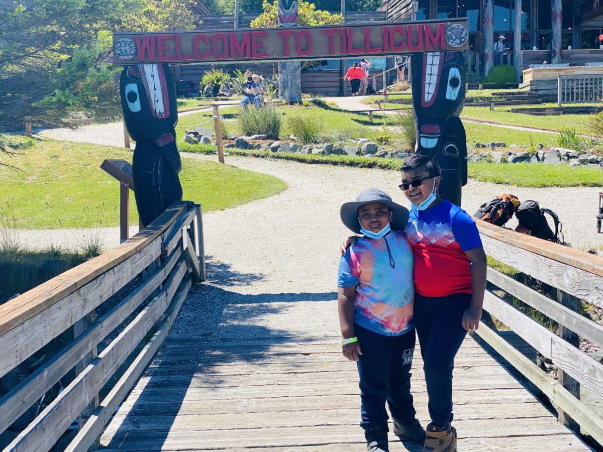 Children stand at the welcome sign at Blake Island