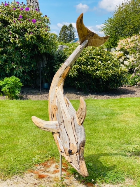 A dolphin sculpture made out of driftwood