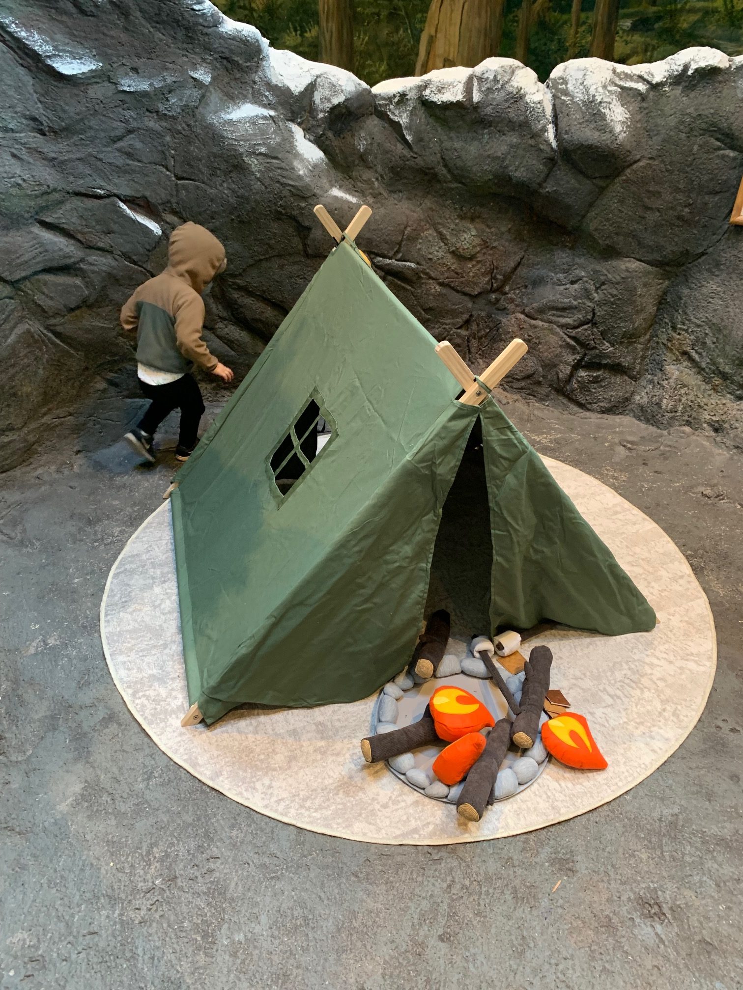 A child runs around a camp site set up inside the museum.