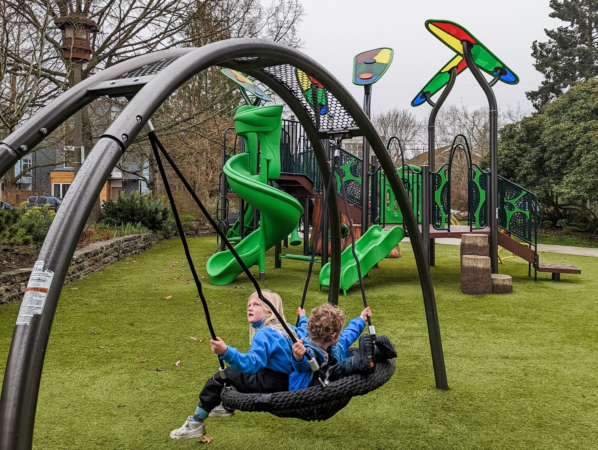 Two kids in a bucket swing