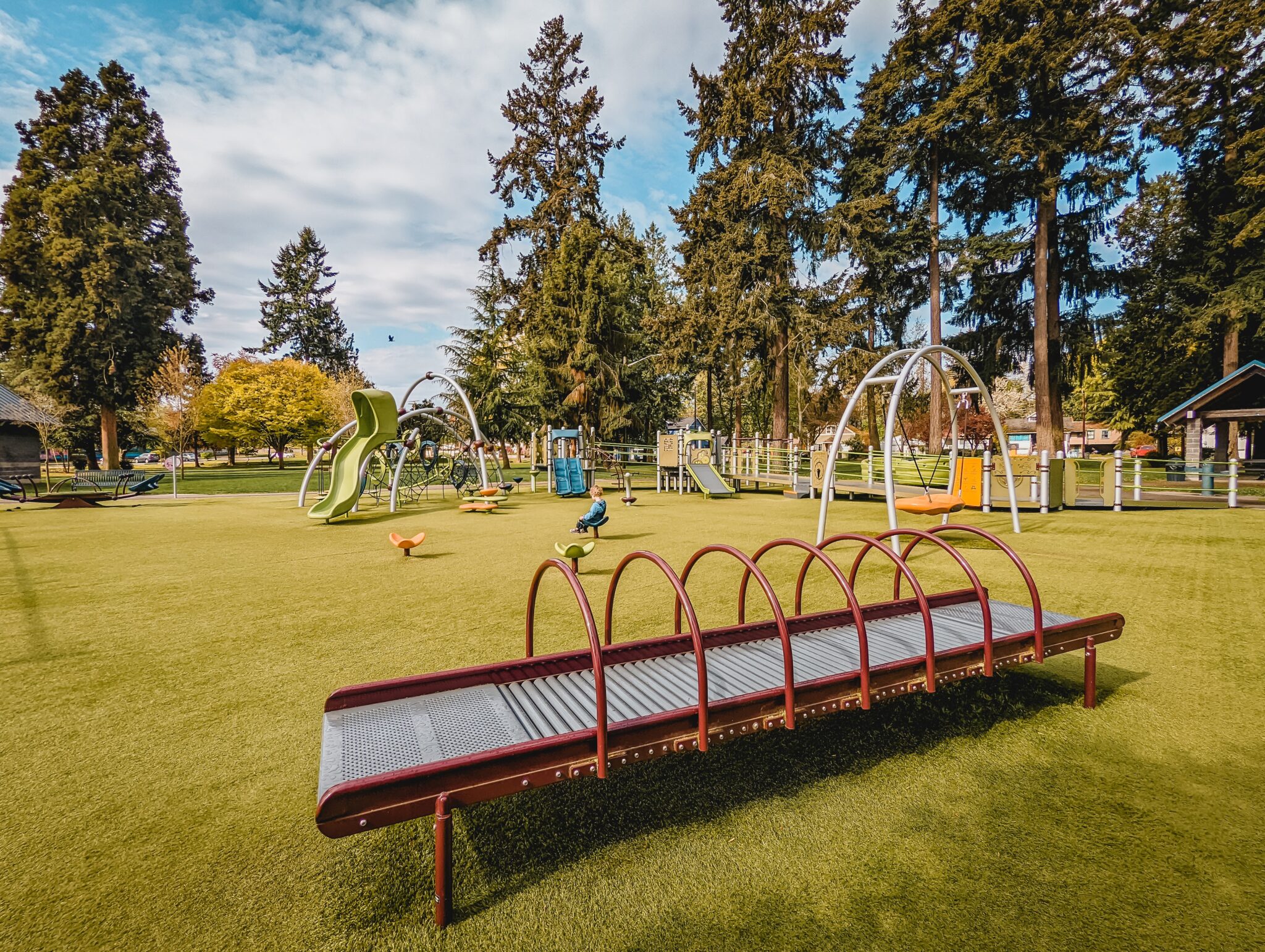Close up of slide, against the backdrop of a large play area. 