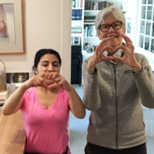 Two women holding their hands together to make a heart shape