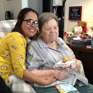 A caregiver giving a senior woman a hug