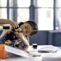Girl building a robot on a table