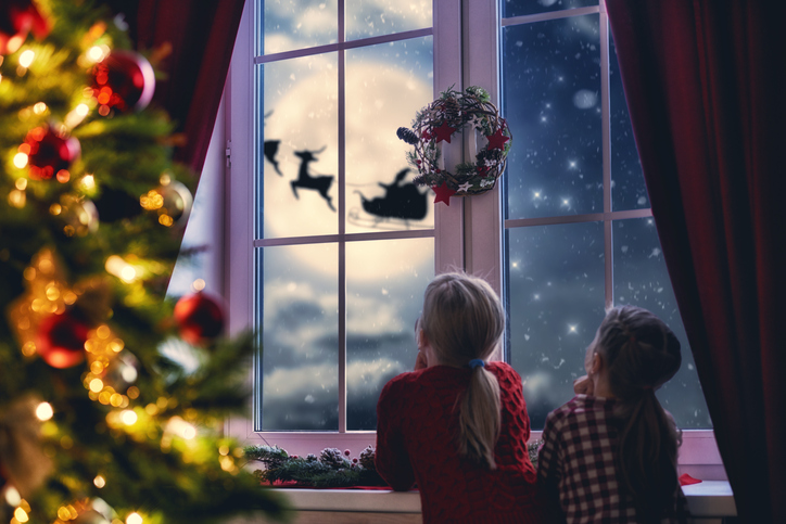 Illustration of kids looking out the window at Santa