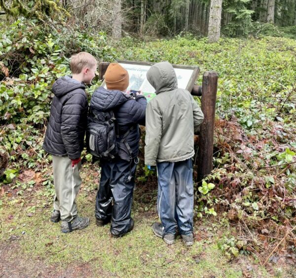 Three kids huddle around park map