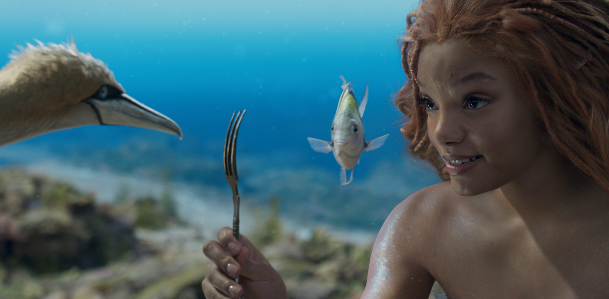The Little Mermaid and her pals look at an unusual object - a fork