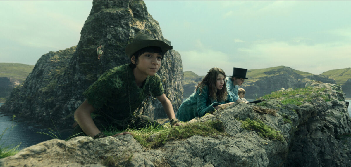 Peter Pan and the Lost Boys peering over a clliff
