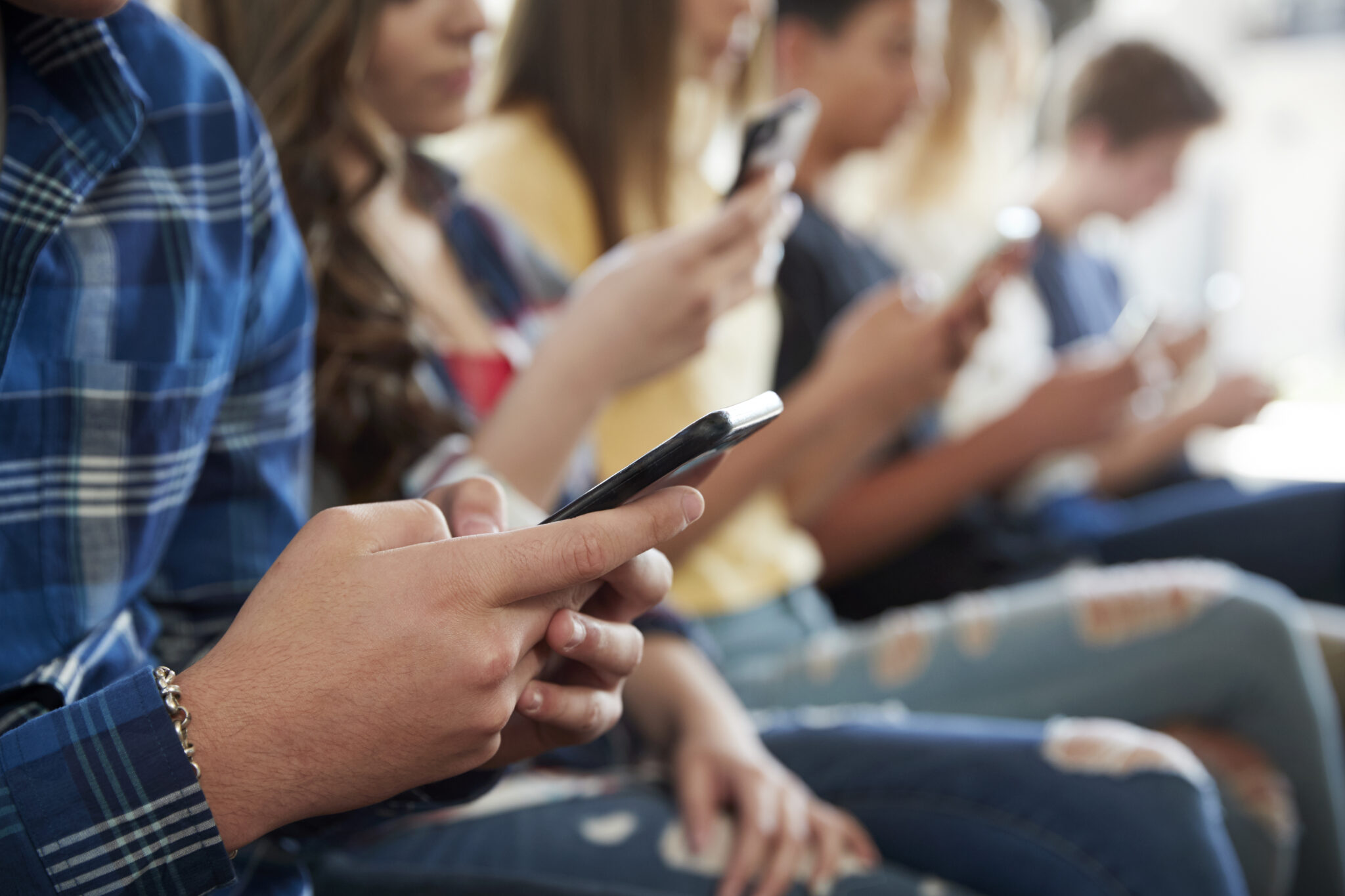 Teens using their phone to check social media which and advisory US Surgeon General Dr. Vivek Murthy days may be harmful to their health