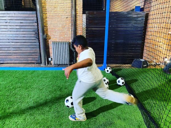 Boy kicking the soccer ball at a LEGO press event