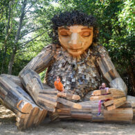 Giant troll sculpture Pia the Peacekeeper sitting cross-legged with arms outstretched, located in Sakai Park on Bainbridge Island, part of the Northwest Trolls project.