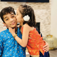A family decorates their home with glowing diya lamps and marigold garlands for Diwali.