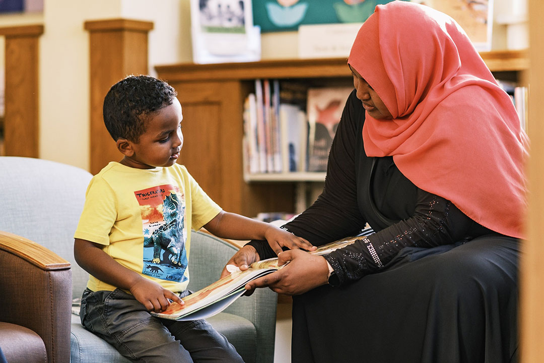 Mother and son looking at a book at the library