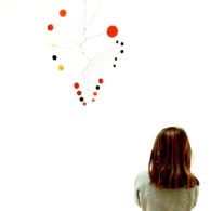 Calder mobiles in primary colors capture the attention of Cora, age 7. Photo by Elizabeth Hunter