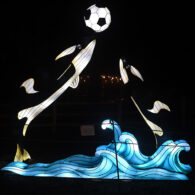 Orca-themed lantern display at WildLanterns showing two illuminated orcas playing soccer at Woodland Park Zoo.