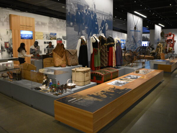 Interior of the National Nordic Museum, showcasing an exhibit complete with dolls, figurines, traditional Nordic dresses in reds, greens, blacks and golds.