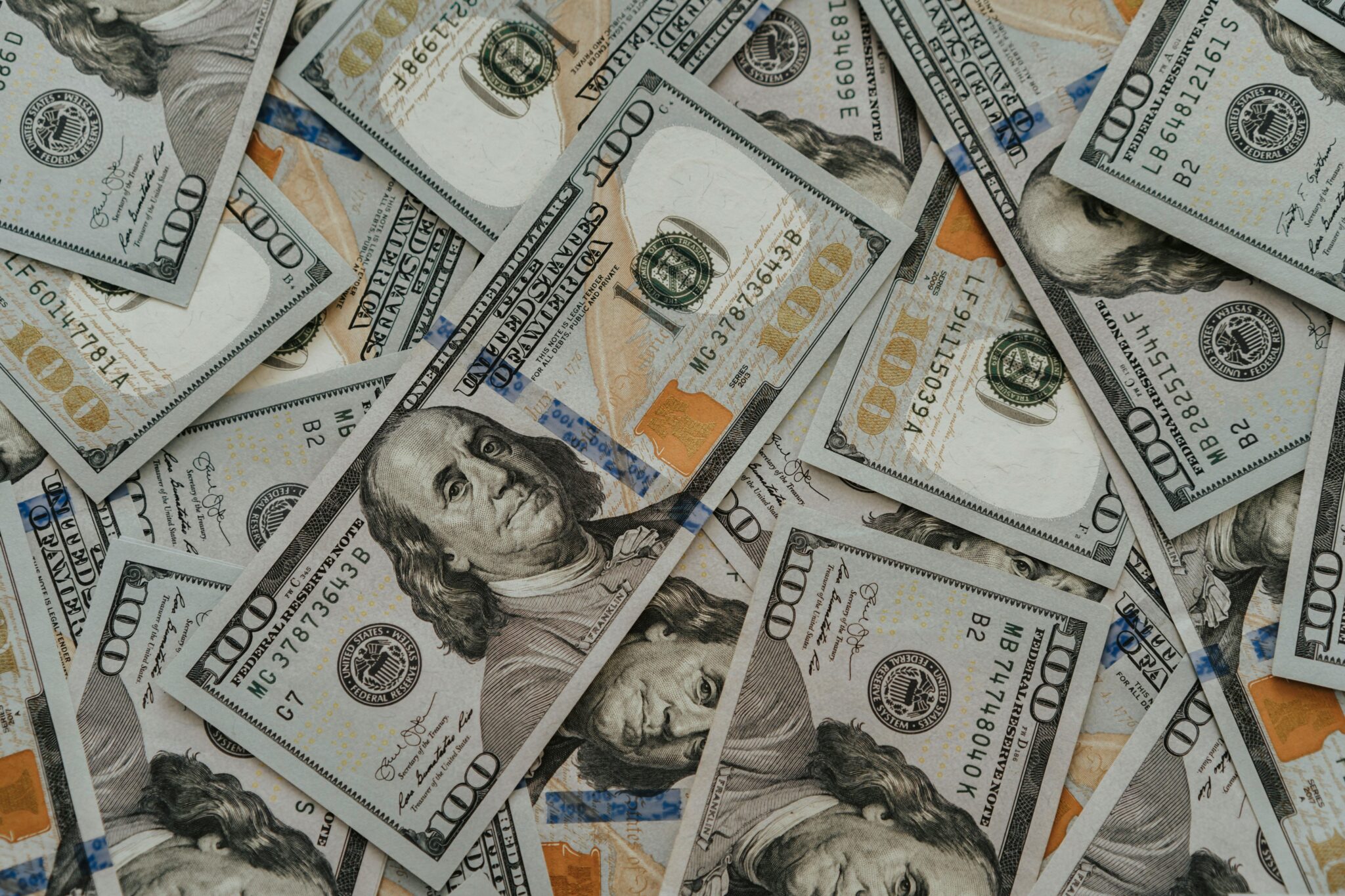 Hundred dollar bills lying on top of eachother.