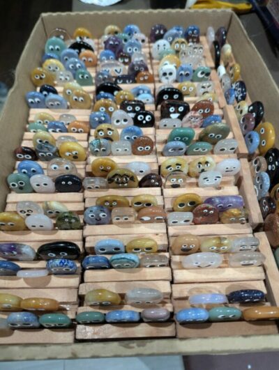 Dozens of tiny geode rocks with googly eyes on them, on a table at at Gem Show.