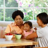 kids and loneliness child at table with adults, bowls of fruit