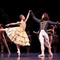 Female dancer holds hands with dancer dressed as a Beast