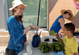 A volunteer helping a child learn about plants at the Beacon Arts Street Fair is July 8th, 2023