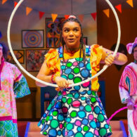 Girl holds hula hoop up on stage