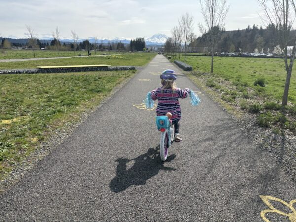 Little kid riding her bike along a park path