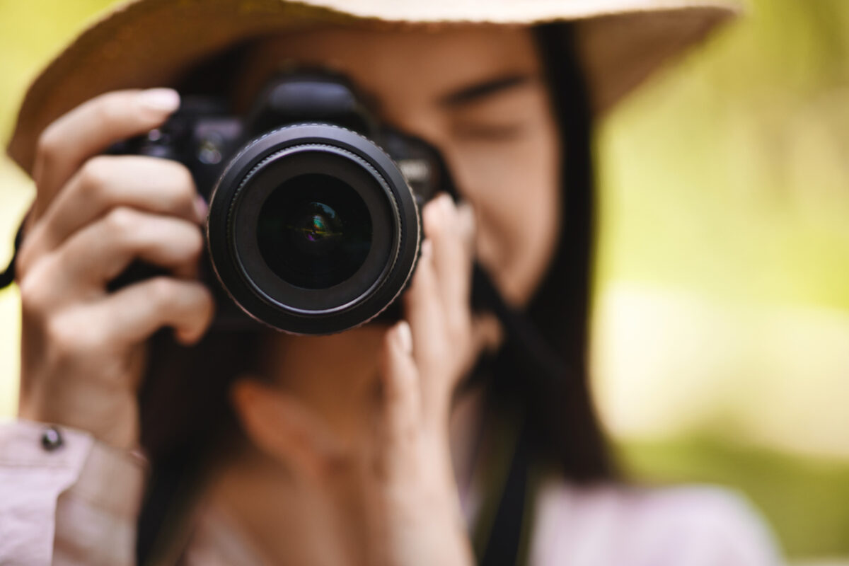 Female Photographer Taking Shot Outdoors With Modern Camera, Selective Focus On Lens