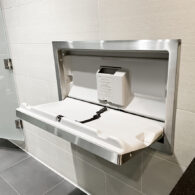 A baby changing station installed in a clean, modern public restroom.