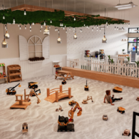 Large indoor sandbox at The Sand Garden in Issaquah with toy trucks, wooden bridges, and children playing.