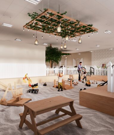 Large indoor sandbox at The Sand Garden in Issaquah with toy trucks, wooden bridges, and children playing.