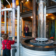 A child explores at Hands On Children’s Museum in Olympia, surrounded by water play and treehouse structures.