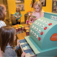 A young child builds with blocks in the Construction Zone at KidsQuest Children’s Museum in Bellevue, surrounded by colorful, hands-on exhibits.