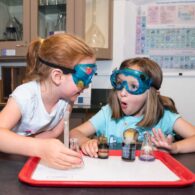Children observes a hands-on experiment inside the Oregon Museum of Science and Industry (OMSI) in Portland, surrounded by interactive science exhibits.