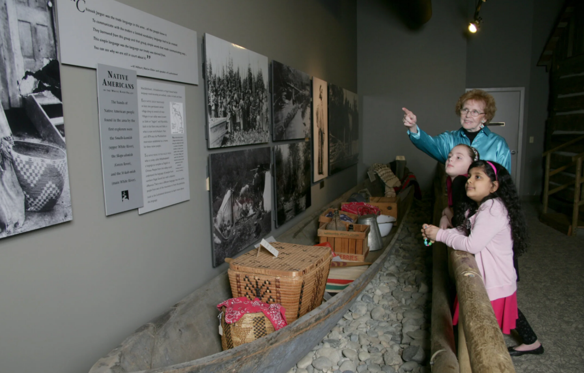 Children look at a historic caboose at the White River Valley Museum in Auburn, surrounded by interactive exhibits that bring local history to life.