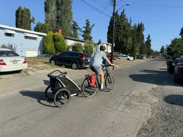 Dad bikes with child on the way to preschool.